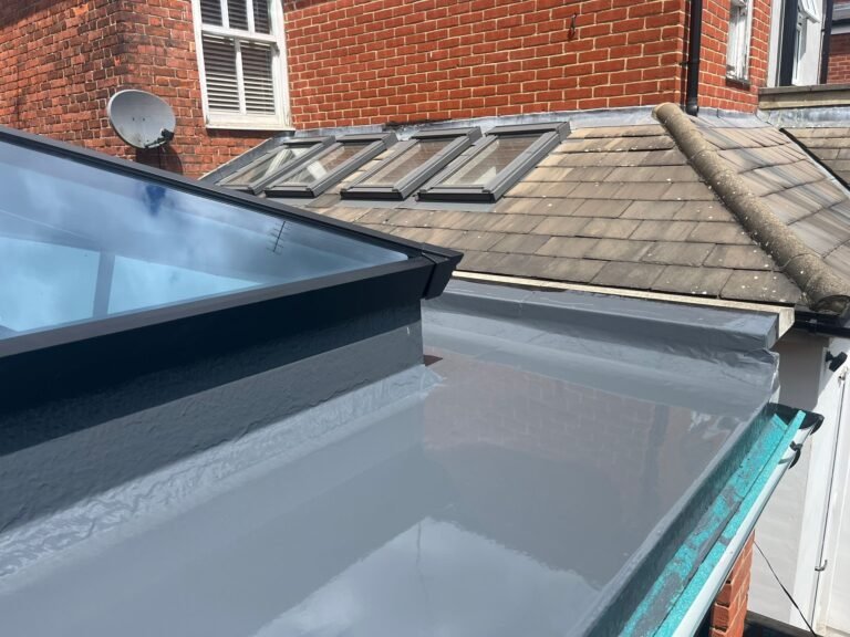 Liquid waterproofing around a glazed rooflight and adjoining roof